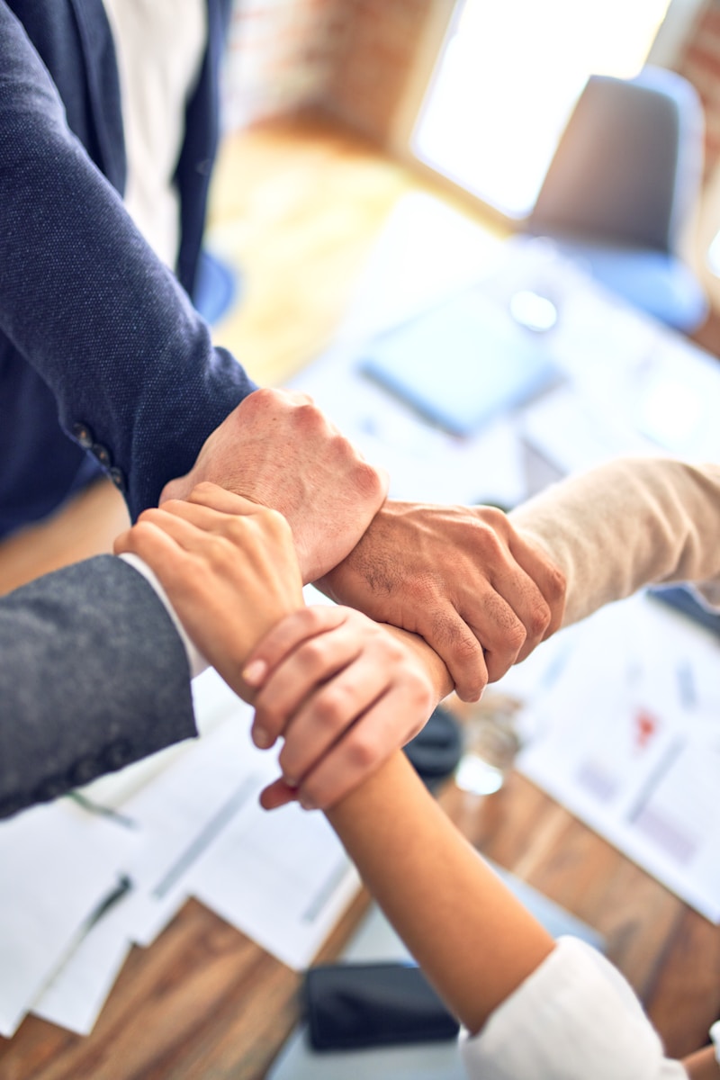 person in black long sleeve shirt holding persons hand with bonds insurance